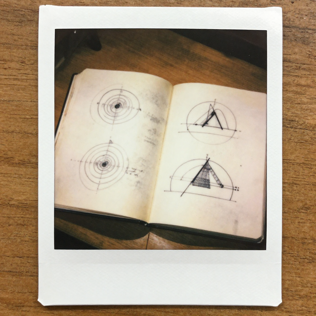 instant Polaroid photograph, vintage 1970s aesthetic, faded colors, white border frame, slightly overexposed, nostalgic lo-fi quality, amateur snapshot, An open notebook lying slightly off-center on a sunlit wooden desk, its yellowed pages filled with hand-drawn diagrams—faded sketches of spin rotations beside fresher, precise renderings of valley states and tilt-induced phase shifts, graphite lines smudged from frequent tracing, morning light from a nearby window casting soft shadows, the air still with the quiet gravity of an idea finally realized after decades [Z-Image Turbo]